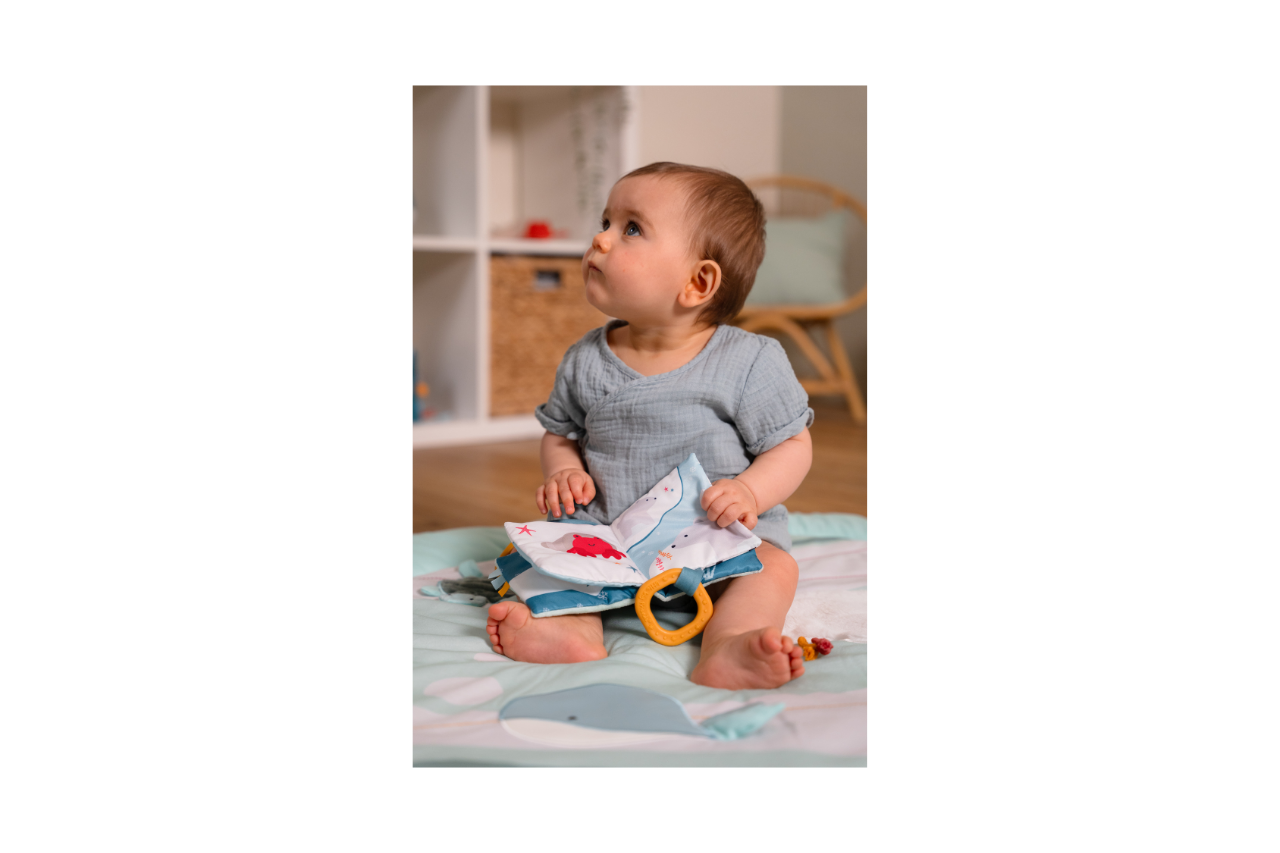 Baby holding open the Soft Baby Book - Ocean