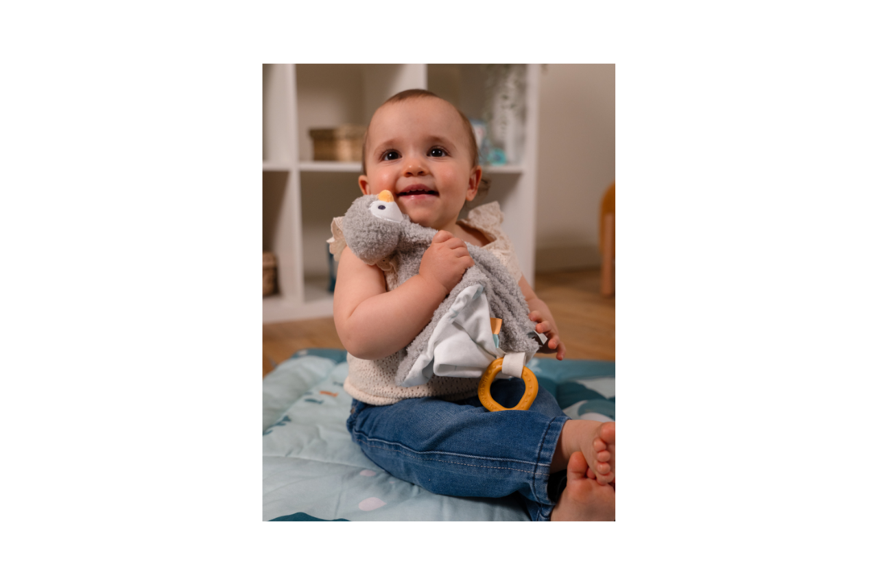 Baby playing with Martin the comforter