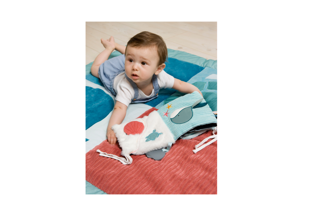 Baby having a tummy time with the Ocean Soft Activity Book 