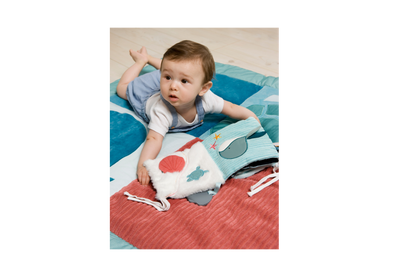 Baby having a tummy time with the Ocean Soft Activity Book 