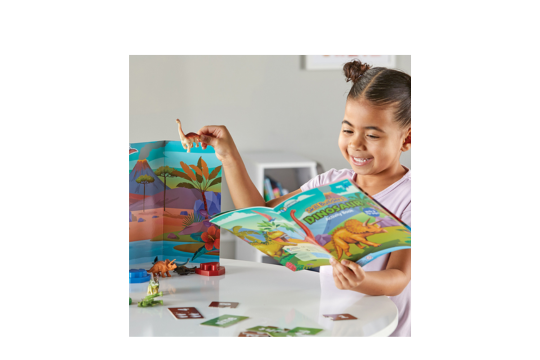 A picture of a little girl happily playing with the Dinosaur activity set.