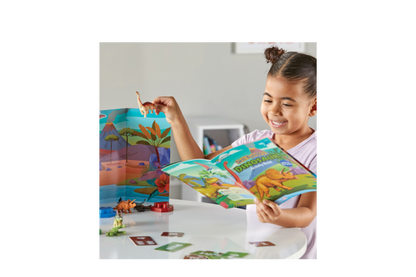 A picture of a little girl happily playing with the Dinosaur activity set.