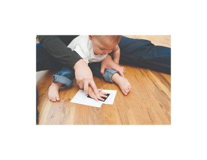 A photo of a parent and child doing the hand print with baby's hand.