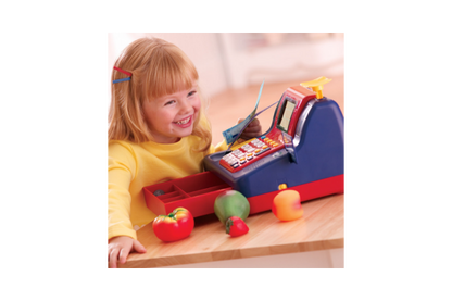 A little girl is pictured playing with the pretend cash register.