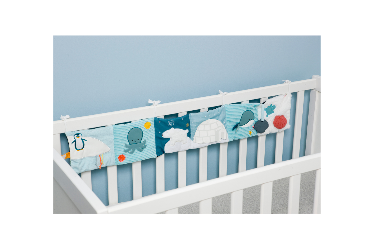 Ocean Soft Activity Book displayed on a crib/strung across the crib slats