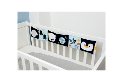 Ocean Soft Activity Book displayed on a crib/strung across the crib slats