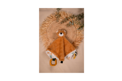 Tim The Tiger-Baby Comforter on a brown background laying on a hand woven tray with green plant branches as decoration